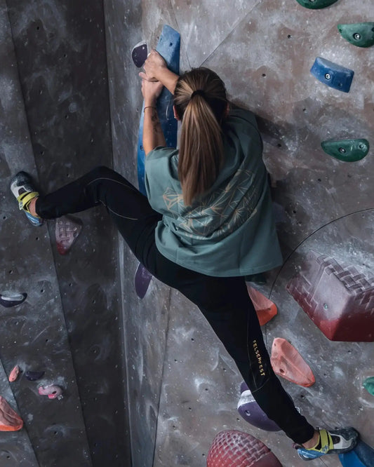 Boulderin in der Felsenfest Boulderhose Obsidian an der Kletterwand
